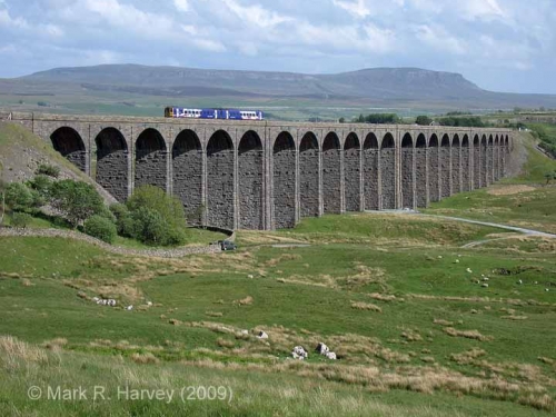 A class 158 train crossing Ribblehead Viaduct, with Pen-y-ghent beyond.